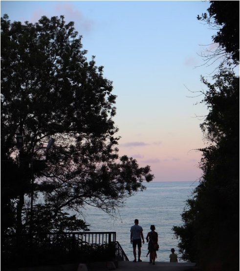 Silhouette d'une famille face à la mer au coucher du soleil
